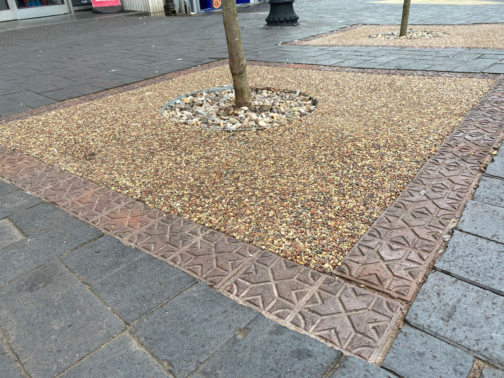 Brown brindle star pavers add detail and create a frame surrounding the tree